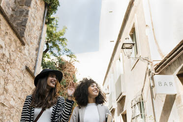 Lächelnde Geschäftsfrauen beim Spaziergang in der Stadt an einem sonnigen Tag - VABF03897