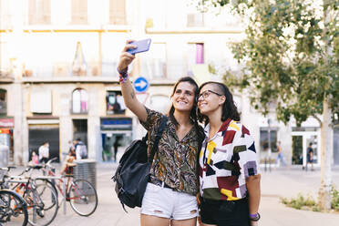 Freundinnen nehmen Selfie auf Smartphone stehen in der Stadt - DGOF01618