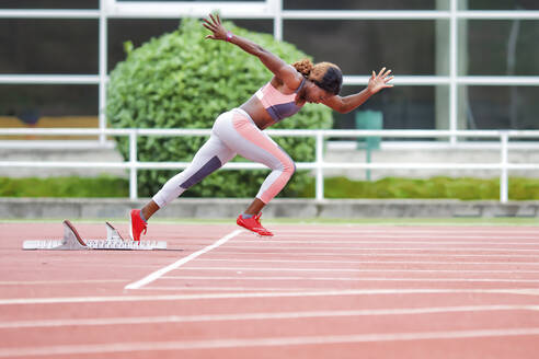 Determinant female athlete running on runner track - GGGF00056