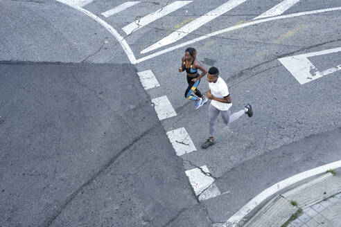 Couple running on road together at city - GGGF00066