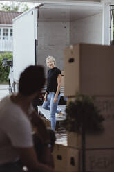 Smiling woman looking at male partner during relocation - MASF20419