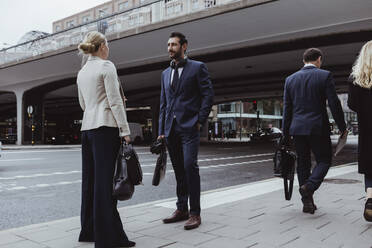 Unternehmer mit Tasche spricht in der Stadt mit einer Mitarbeiterin - MASF20470