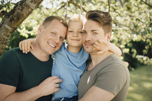 Porträt von homosexuellen Vätern mit Sohn im Hof stehend - MASF20584