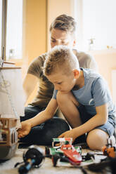 Vater und Sohn basteln Spielzeugboot, während sie am Wochenende zu Hause sitzen - MASF20602