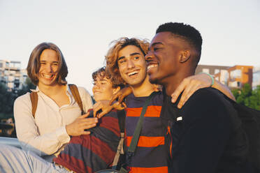 Lächelnde junge und männliche Freunde im Teenageralter genießen gemeinsam in der Stadt - MASF20715