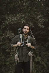 Portrait of man with backpack in forest - MASF20905