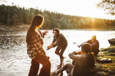 Männliche und weibliche Freunde genießen am See im Wald - MASF20934