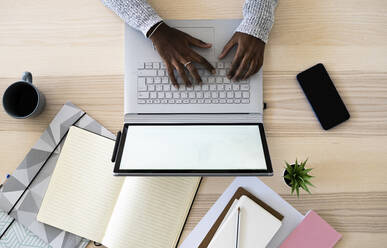 Hände einer Unternehmerin, die beim Lernen zu Hause einen Laptop benutzt - GIOF09630