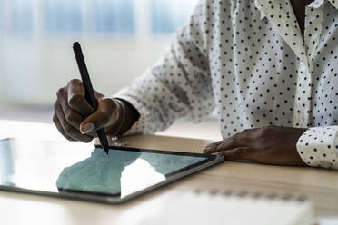 Weibliche Hand schreibt auf digitalem Tablet im Wohnzimmer zu Hause - GIOF09679