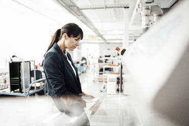 Businesswoman using computer at industry - JOSEF02206