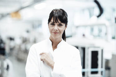 Confident smiling female scientist standing in bright laboratory - JOSEF02248