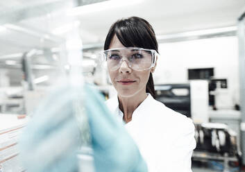 Confident mature female scientist wearing protective eyewear at laboratory - JOSEF02302