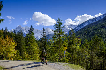 Male biker admiring forested Gleirschtal valley in summer - LBF03264