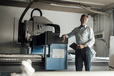 Männlicher Ingenieur mit digitalem Tablet an einer Produktionsanlage in einer Fabrik - JOSEF02501