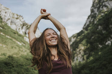 Cheerful female trekker with tousled brown hair enjoying during hiking - DMGF00280