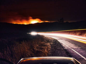 Unscharfe Scheinwerfer auf einer dunklen Straße, Woodward Fire brennt in Point Reyes. - CAVF90269