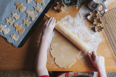 Junges Mädchen rollt Lebkuchenteig mit einem Nudelholz aus - CAVF90305