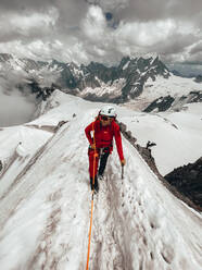 Young female climber on narrow snow ridge above glaciers Mt Blanc - CAVF90319