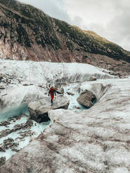 Junge Bergsteigerin bei der Flussüberquerung auf dem Gletscher Mer de Glace - CAVF90321
