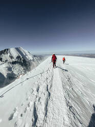 Seilschaft beim Abstieg auf den Mont Blanc unter dunkelblauem Himmel bei starkem Wind - CAVF90327