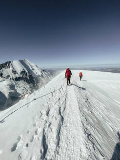 Seilschaft beim Abstieg auf den Mont Blanc unter dunkelblauem Himmel bei starkem Wind - CAVF90327