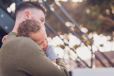 Baby lehnt sich an Papas Schulter und Papa umarmt es - CAVF90354