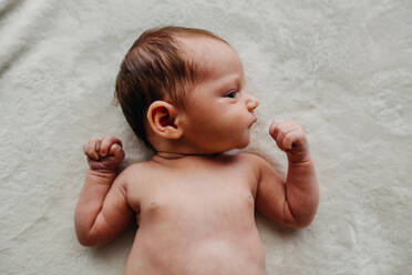 Nahaufnahme des Kopfes eines Neugeborenen mit Blick zur Seite, zu den Schultern und Armen - CAVF90375