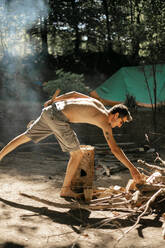 A topless man splitting firewood - CAVF90404