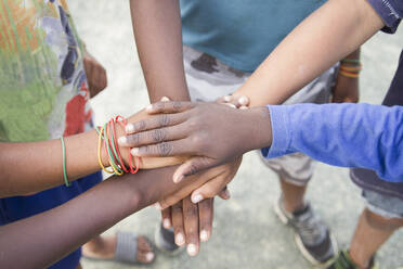 Anonymous group of different race children putting hands together in an outdoor natural environment concept of togetherness - CAVF90542