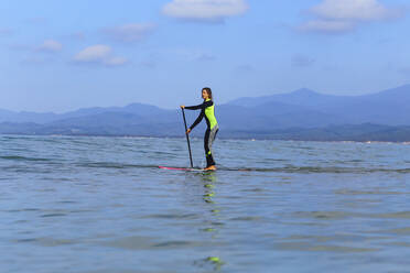 Female SUP surfer on a wave - CAVF90557
