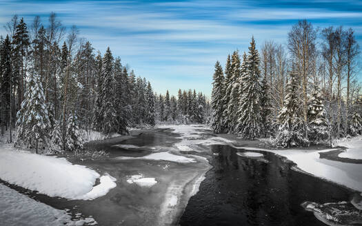 Wilder Fluss, der im Winter vor blauem Himmel durch herrliche Wälder fließt - ADSF17243