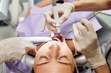 From above of crop patient with braces having cleaning procedure in modern dental clinic - ADSF17277