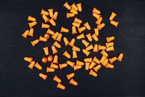 Orangefarbene Ohrstöpsel auf schwarzem Hintergrund - ABAYF00018