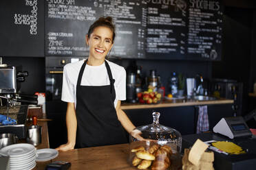 Portrait of smiling waitress working at cafe - BSZF01792