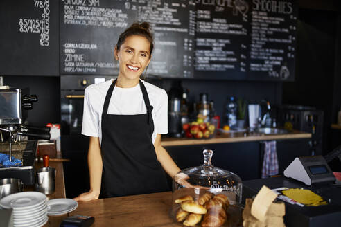Porträt einer lächelnden Kellnerin in einem Cafe - BSZF01792