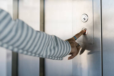 Die Hand einer Frau drückt die Aufzugstaste am Bahnhof - EGAF01004