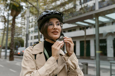 Frau mit Fahrradhelm auf der Straße in der Stadt - VABF03971