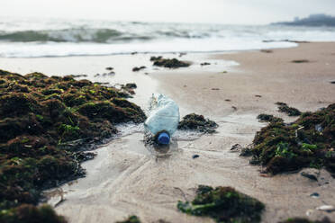 Garbage and water bottle on beach - OYF00249