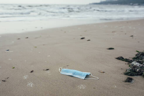 Verlassene Gesichtsmaske am Strand - OYF00252