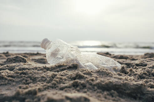 Plastikwasserflasche auf Sand am Strand - OYF00256