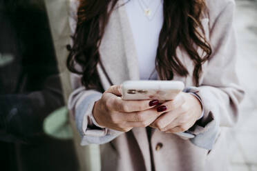 Hand of woman using smart phone in city - EBBF01476