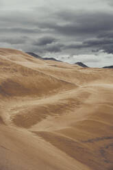 Majestic scenery of sand dunes and mountains under overcast sky in National Park in Colorado - ADSF17371