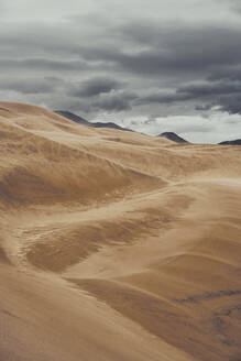 Majestätische Landschaft mit Sanddünen und Bergen unter bedecktem Himmel im Nationalpark von Colorado - ADSF17371