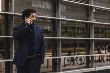 Entrepreneur talking on mobile phone while standing in city - PNAF00056
