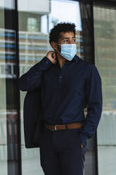 Entrepreneur wearing protective face mask in city - PNAF00070