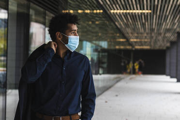 Businessman wearing protective face mask in city - PNAF00071