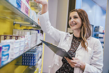 Apothekerin mit Schutzmaske bei der Arbeit in der Apotheke - MFF06858