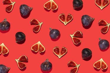 Directly above shot of fig fruit arranged on red background - GEMF04391