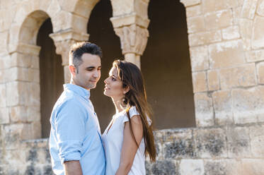 Woman admiring boyfriend while standing by Roman church - JMPF00580