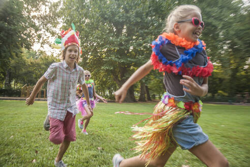 Fröhliche Kinder in Kostümen laufen im Park - AJOF00590